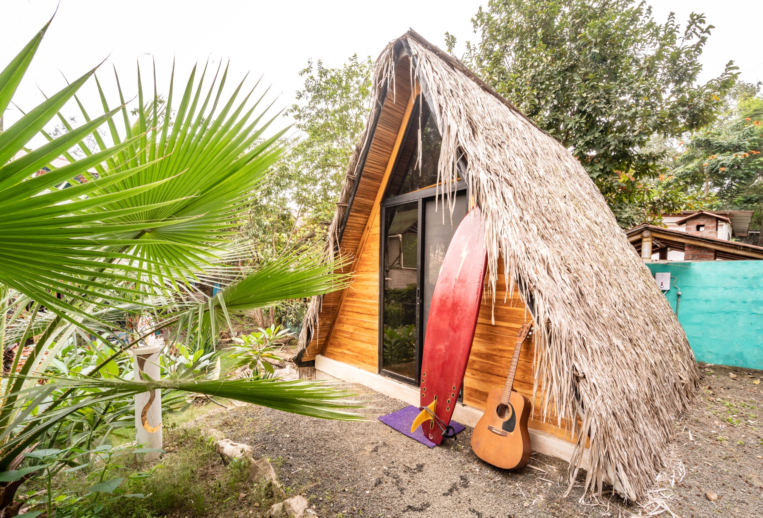 Tropical cabin with surfboard and guitar outside